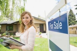 Realtor in front of "for Sale" sign